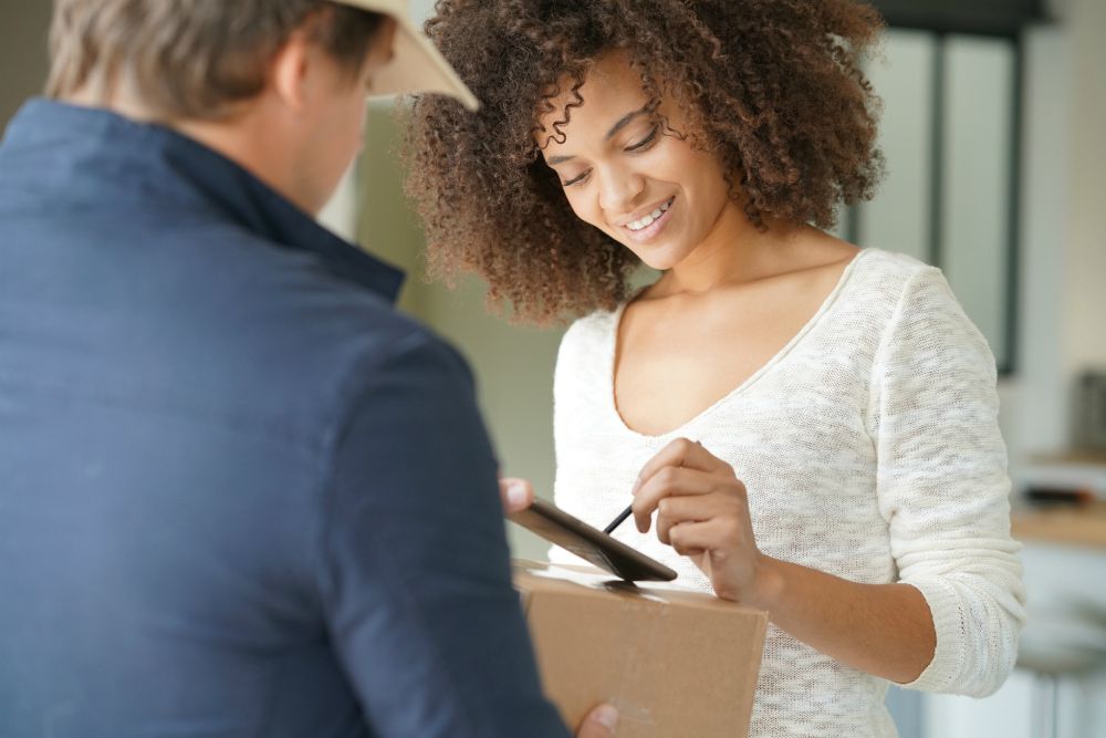 woman of color signing delivery box of subscription at home | Secrets to Successful Account Management with Suneal Rao at InsideSales.com | account management | key account management