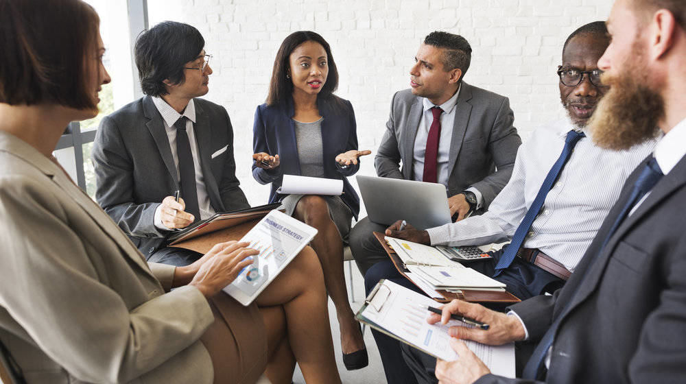 Group of 6 business people discussing in a meeting room | Feature Image